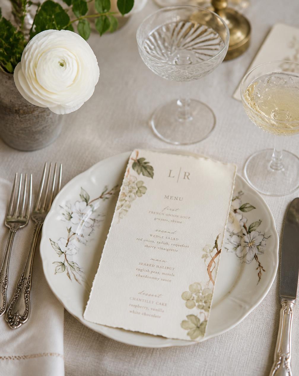 Hand-painted menu card on a vintage floral plate